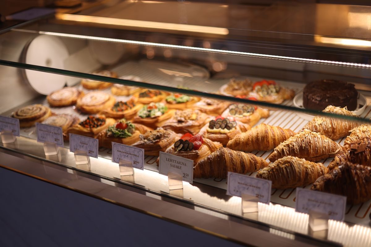 Cafédiisplay fyldt med kager, muffins og kanelsnegle