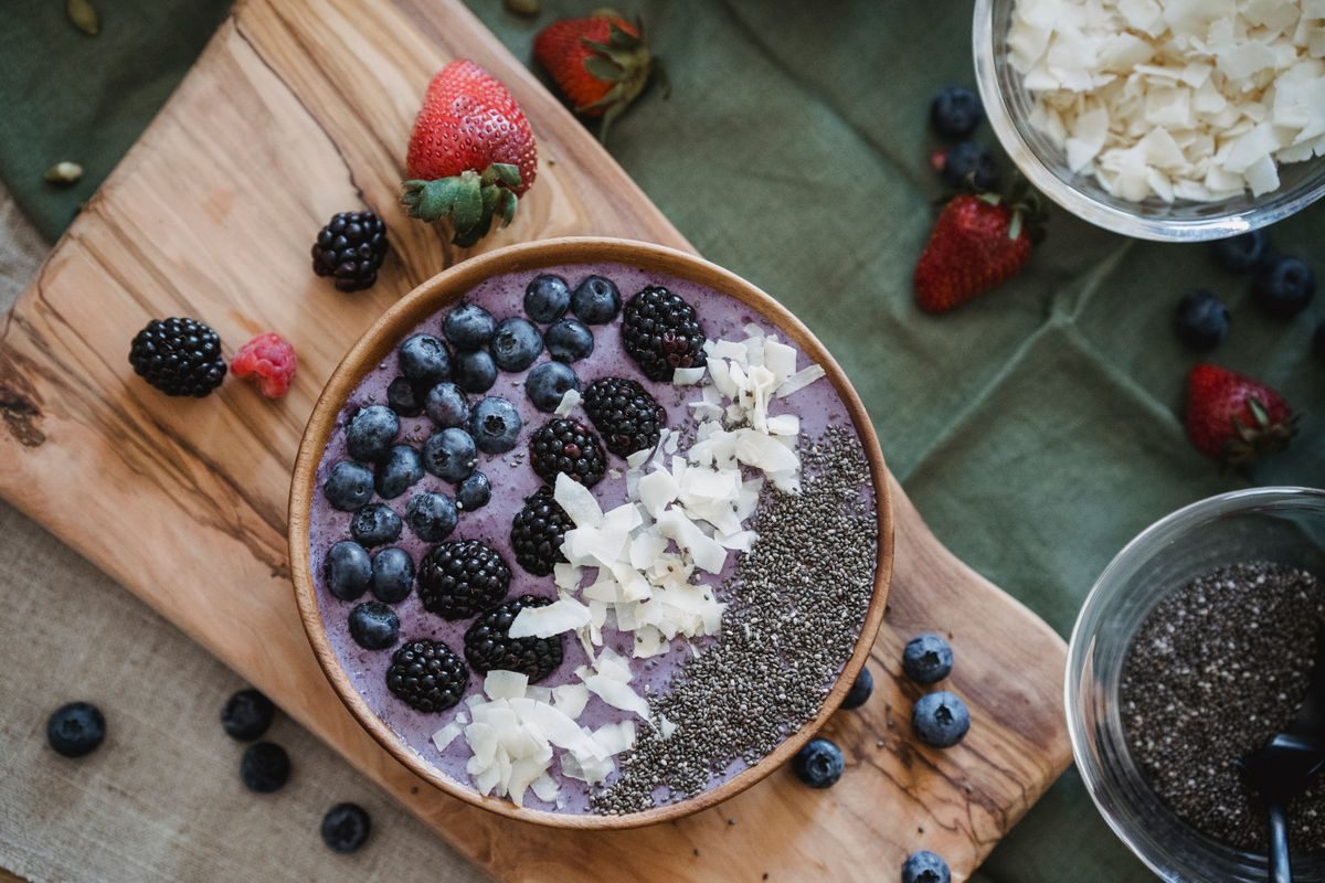 Farverige smoothies med bær og banan ved siden af i lyst lys