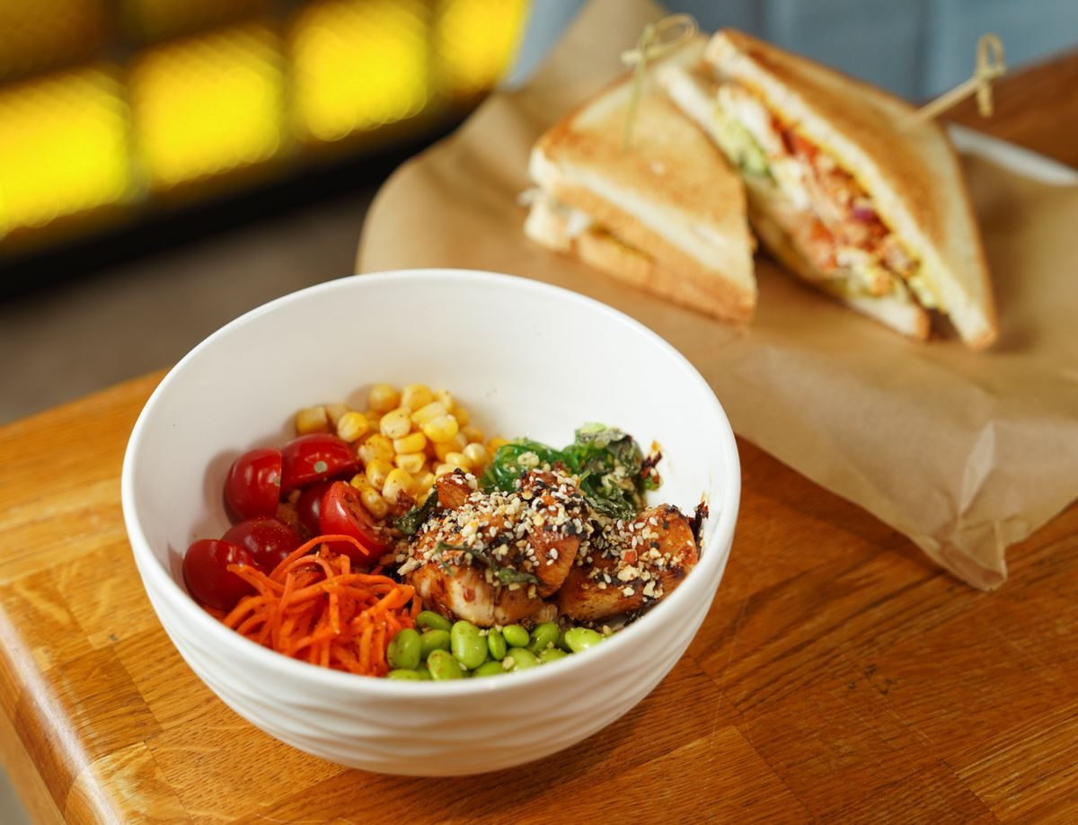 Frisk sandwich og salat med tomater på et cafebord