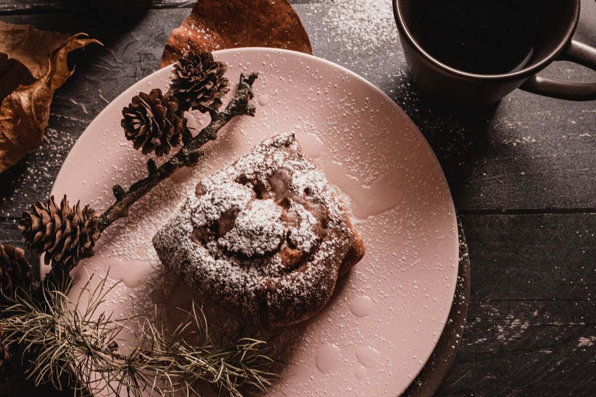 Kanelstang og kaffe ved siden af et ur, der illustrerer hvor mange minutters arbejde den koster