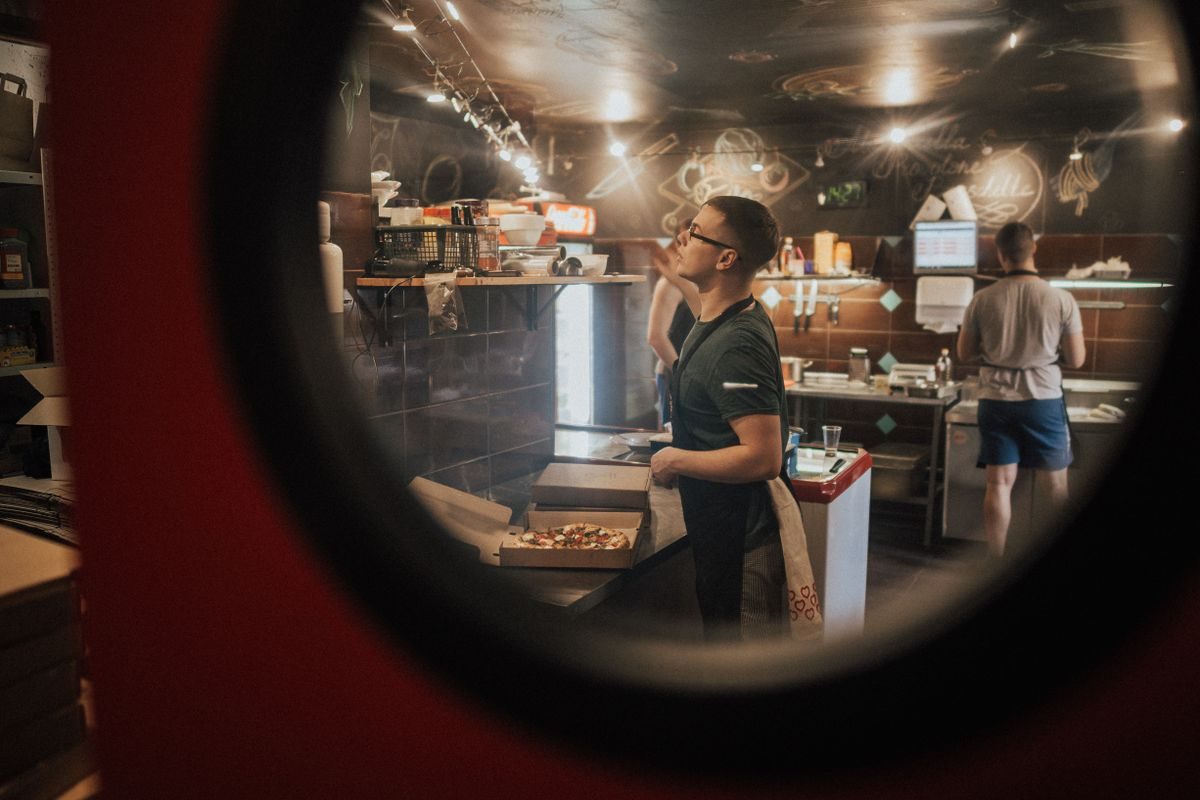 Moderne pizza restaurant interiør med træborde og varm belysning