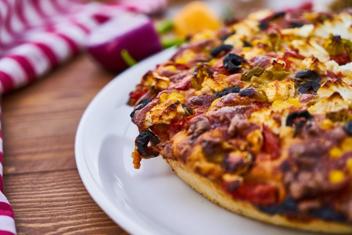 Næringsindhold i pizza illustreret med forstørrelsesglas